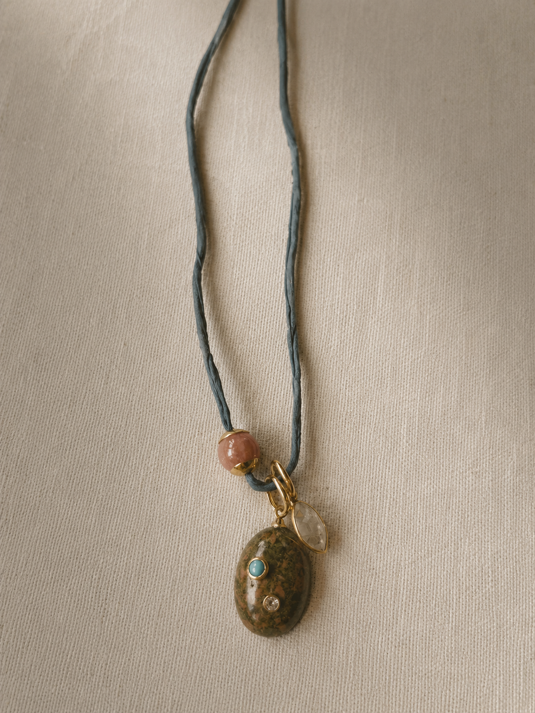 Aeris silk necklace with stone blue silk, unakite bezels with turquoise and moissanite accents, lemon topaz charm, and sunstone details.